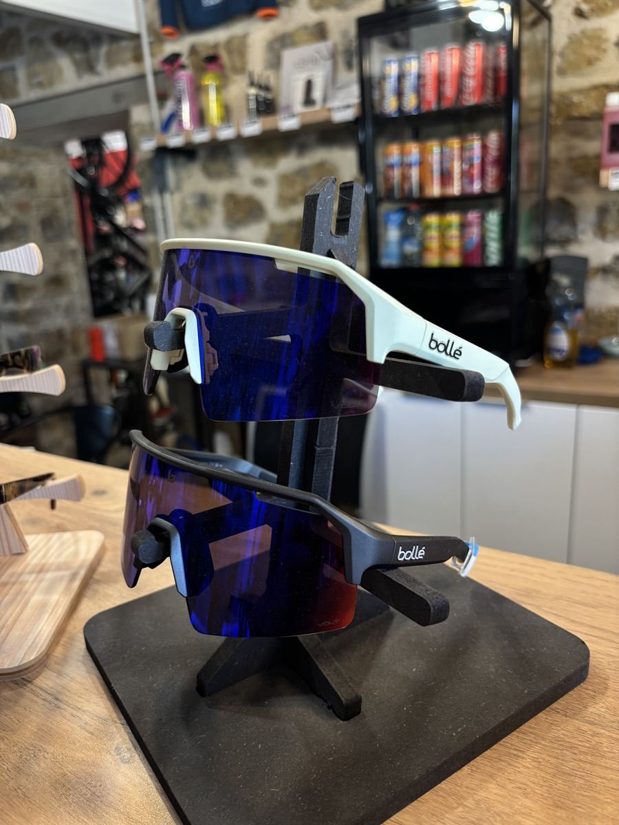 Lunettes de cyclisme sur un présentoir, frigo à boissons en arrière-plan